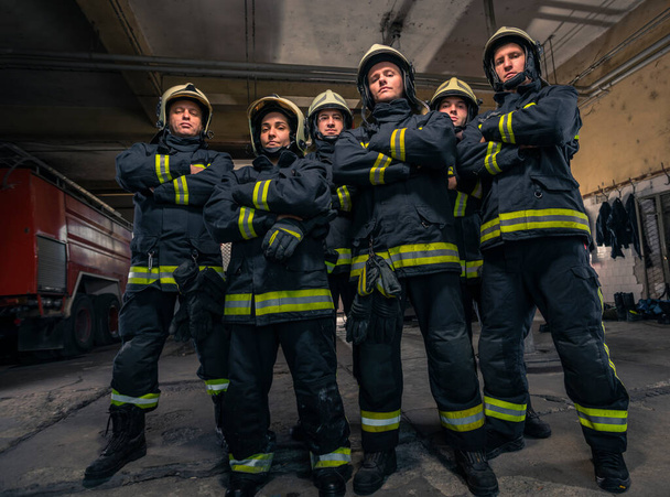 Groupe de pompiers en confiance avec les armes croisées. Pompiers prêts pour le service d'urgence. - Photo, image