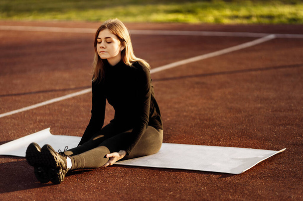 Young fit woman exercising in park - Fotó, kép