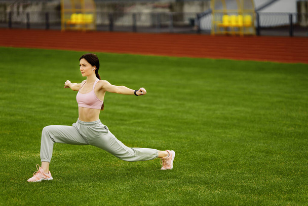 Young fit woman exercising on stadium  - Photo, image