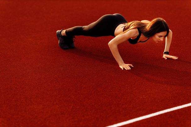 Young fit woman exercising on stadium  - Foto, Bild