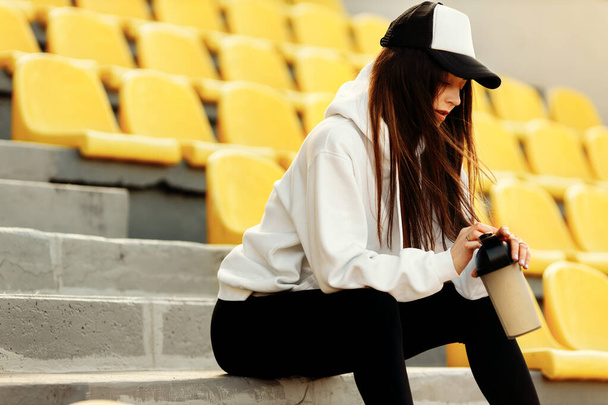 Young fit woman   with coffee  on stadium  - Fotografie, Obrázek
