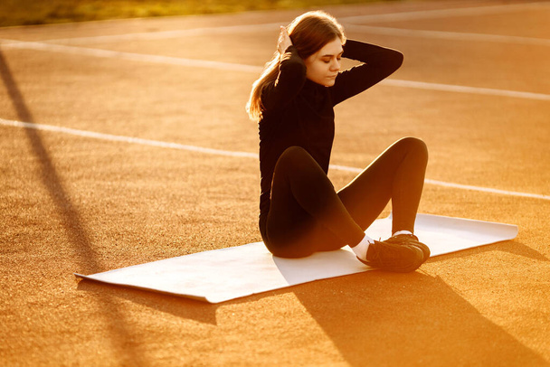 Young fit woman exercising in park - Fotó, kép