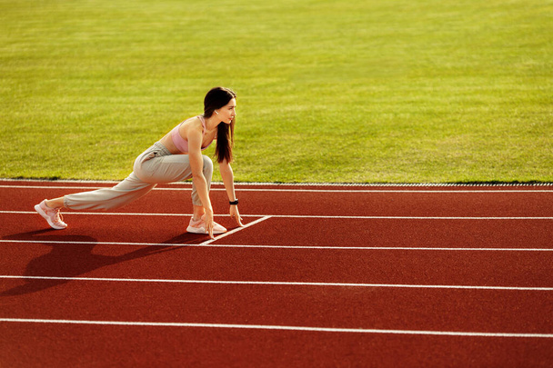 Young fit woman exercising on stadium  - Valokuva, kuva