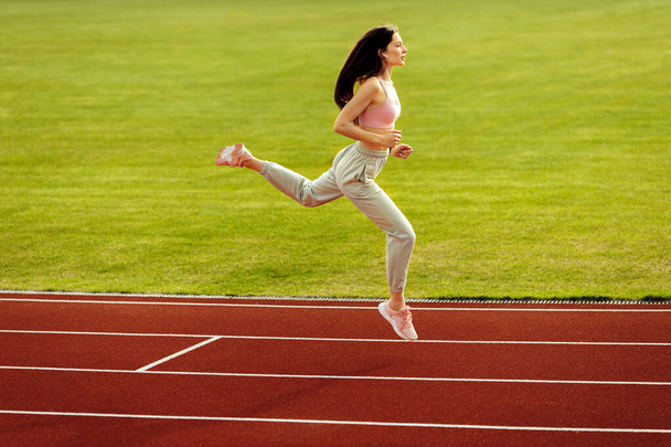 Young fit woman exercising on stadium  - Valokuva, kuva