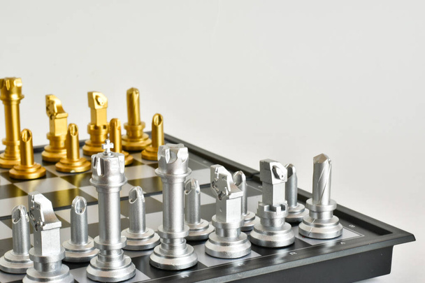 Golden and silver chess pieces on a chessboard close-up on a white background. Checkmate. Queen, king, pawn - Foto, Imagen