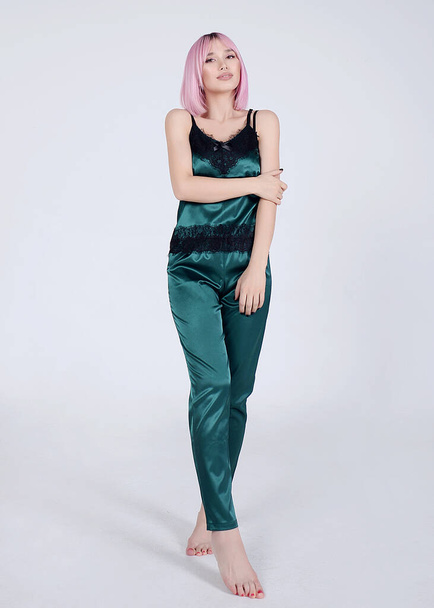 beautiful girl on colored backgrounds in silk and velvet pajamas and home costume - 写真・画像