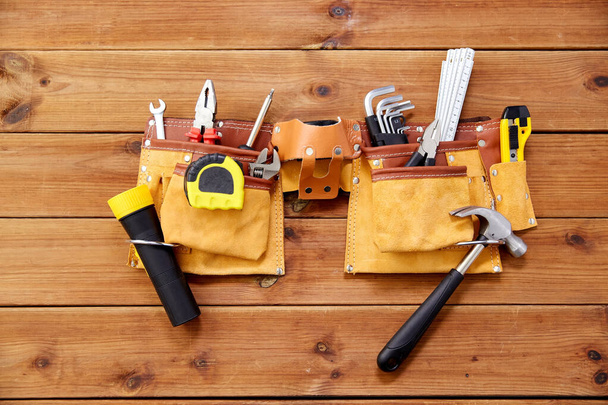 different work tools in belt on wooden boards - Fotó, kép