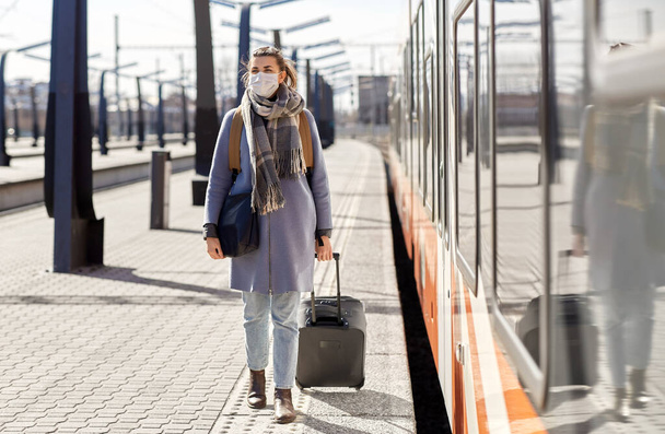 woman in protective face mask at railway station - Zdjęcie, obraz