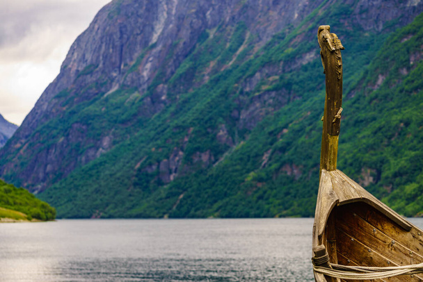 Old wooden viking boat on fjord shore. Mountains and Sognefjord. Tourism and traveling concept - Foto, immagini