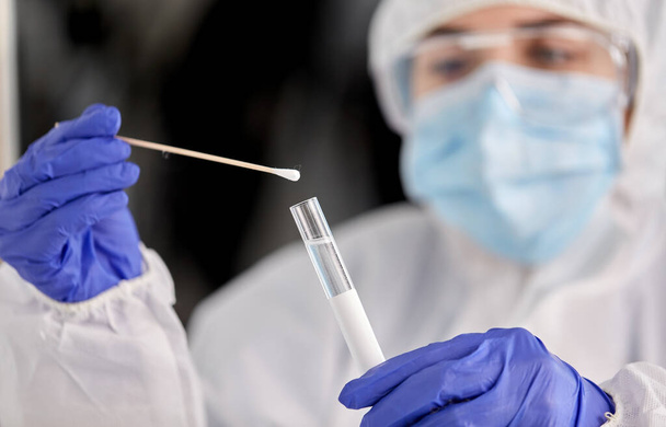 scientist holding beaker with coronavirus test - 写真・画像