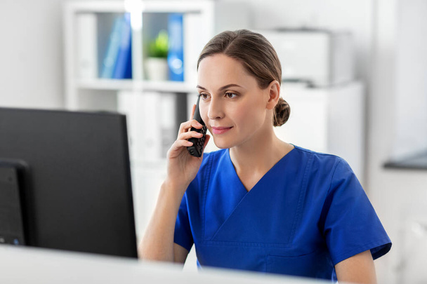 doctor with computer calling on phone at hospital - Valokuva, kuva
