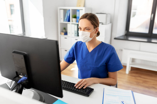 doctor or nurse in mask with computer at hospital - Photo, Image