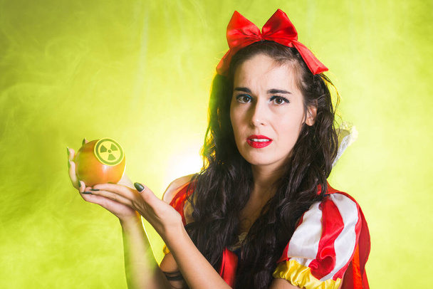 Gefahr, Kernkraft und Strahlenmessung - Mädchen hält Apfel mit Strahlenrisiko-Symbol. - Foto, Bild