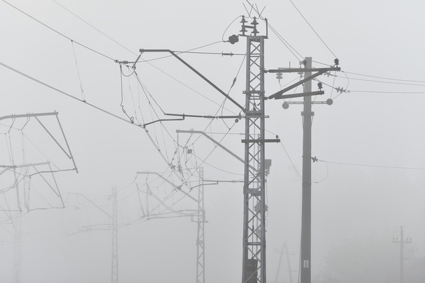 Lignes électriques de câbles ferroviaires dans un brouillard intense
 - Photo, image