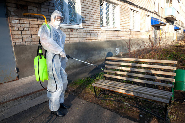 Disinfection of a bench in the courtyard of an apartment building. Fight against viruses, infections, insects, mice - Fotó, kép
