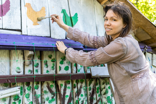Femme peignant une maison à la campagne du village
. - Photo, image