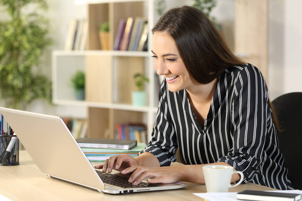 Happy entrepreneur woman typing on laptop sitting on a desk at homeoffice - Fotoğraf, Görsel