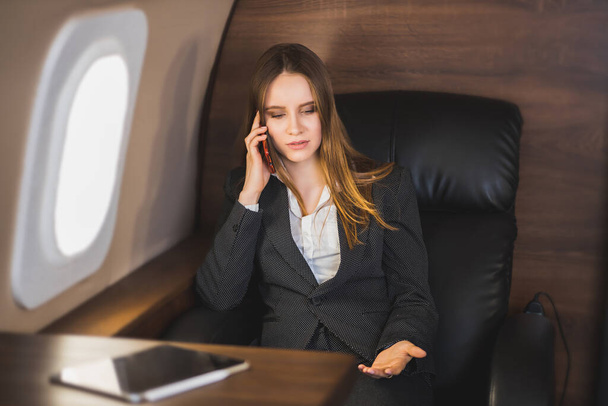 Attractive woman in private jet - Zdjęcie, obraz
