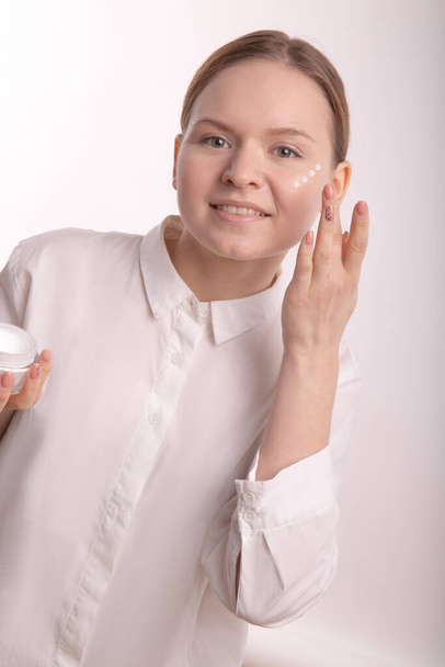 Vertical photo of a girl with the application of the cream. - Foto, afbeelding