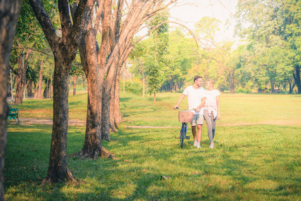 Portrait image of Young couple enjoying in the park at sunset. Concept romantic and love. Warm tone. - 写真・画像