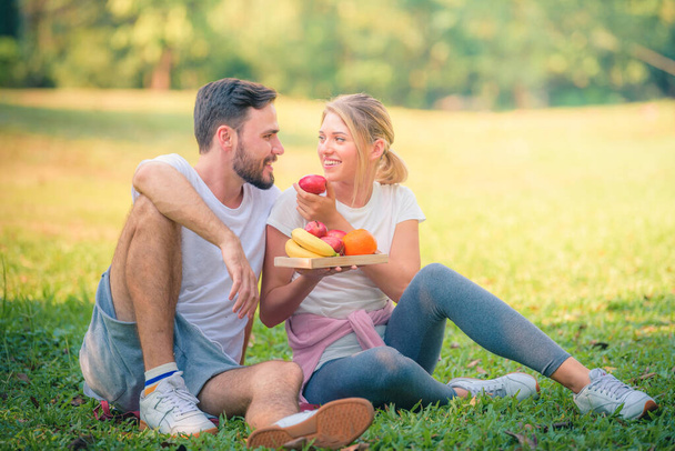 Retrato de una joven pareja disfrutando en el parque al atardecer. Concepto romántico y amor. Tonalidad cálida
. - Foto, imagen