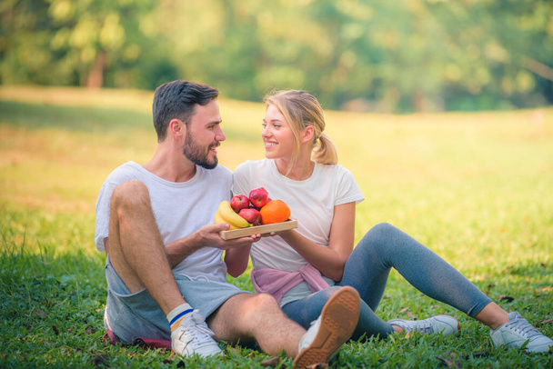Retrato de una joven pareja disfrutando en el parque al atardecer. Concepto romántico y amor. Tonalidad cálida
. - Foto, imagen