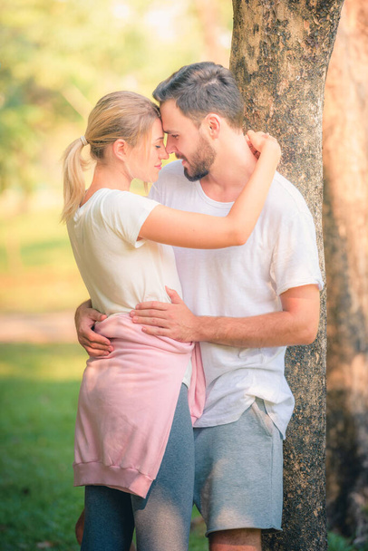 Portraitbild eines jungen Paares, das den Sonnenuntergang im Park genießt. Konzept Romantik und Liebe. Warmer Ton. - Foto, Bild