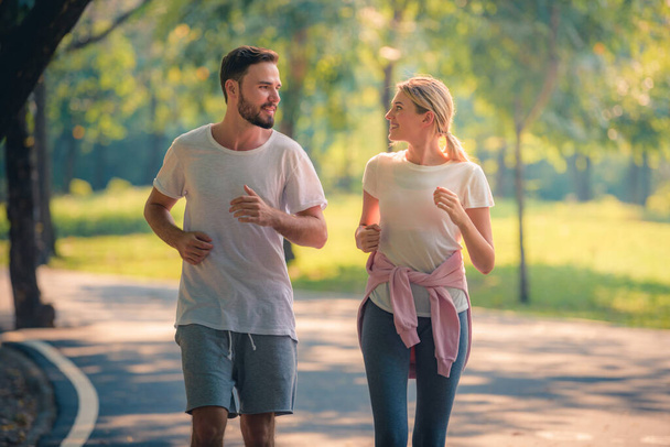 Portrét mladého páru běžícího v parku při západu slunce. Pojem sport a láska. Teplý tón. - Fotografie, Obrázek