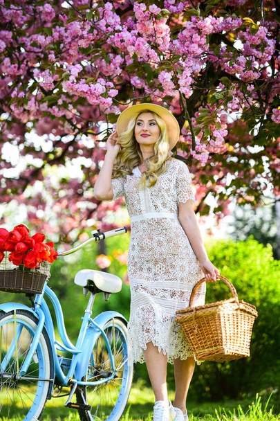 Nice bouquet. relax in park. fashion and beauty. woman ride vintage bicycle. romantic girl under sakura blossom. beautiful spring season nature. cherry tree blooming flowers. pink blossoming sakura - Photo, image