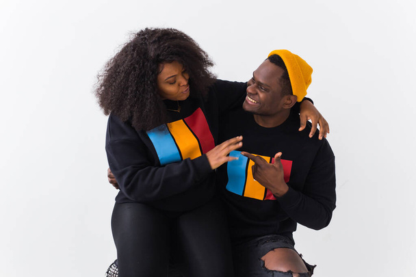 Fröhliche afroamerikanische Frau und Mann haben Beziehungen, zahmes Lächeln, glücklich, sich mit Freunden zu treffen, lässig gekleidet auf weißem Hintergrund. Emotionen und Freundschaftskonzept. - Foto, Bild