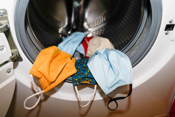 máscara de tecido têxtil coronavírus na máquina de lavar roupa
 - Foto, Imagem