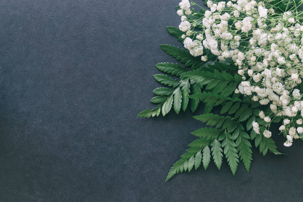 Gypsophila white baby's breath flower on black granite table background with copy space. Isolated beautiful wallpaper for Valentine or wedding backdrop design. Gypsophila flower is mean forever love. - Fotó, kép