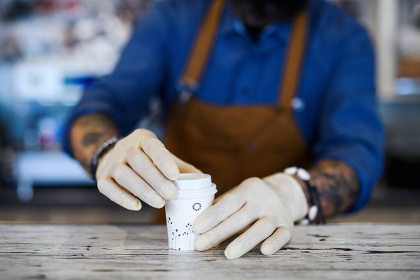 Barista working with gloves, coffee shop open after lockdown quarantine. - 写真・画像