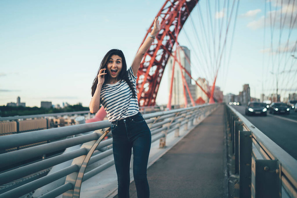 Half length portrait of wonder hipster girl with raised hand satisfied with received news during cellphone communication, excited Asian woman surprised with incoming international phone call - Fotoğraf, Görsel