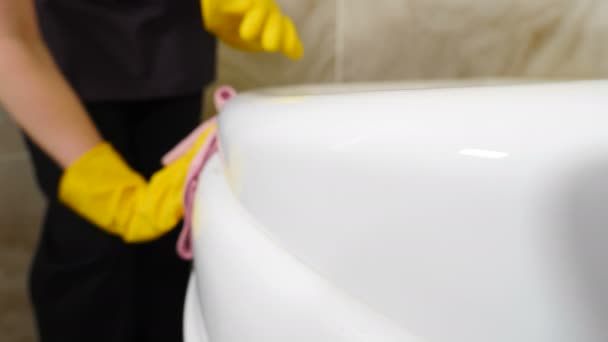 Cleaning in hotel or apartament. Pretty maid from hotel staff cleaning washing sink with a rag. wiping bathtub in bathroom at residential building. Woman cleaning Jacuzzi. 4 k footage - Footage, Video