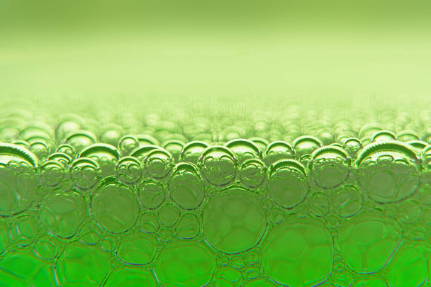 Abstract macro schoon groen schuim shot achtergrond van zeepbellen met licht en kleur reflecties effecten - Foto, afbeelding