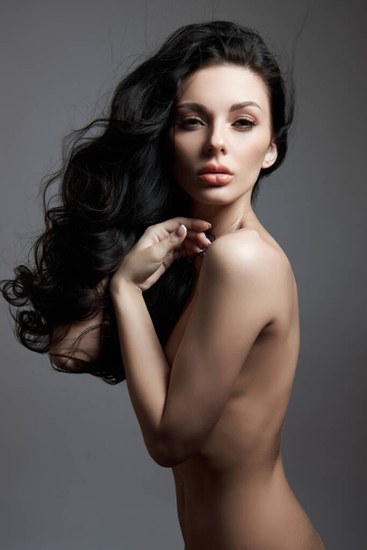 Sexy fashion nude woman with long hair, curly strong hair of a brunette girl. Natural cosmetics for hair care, strong roots - Zdjęcie, obraz