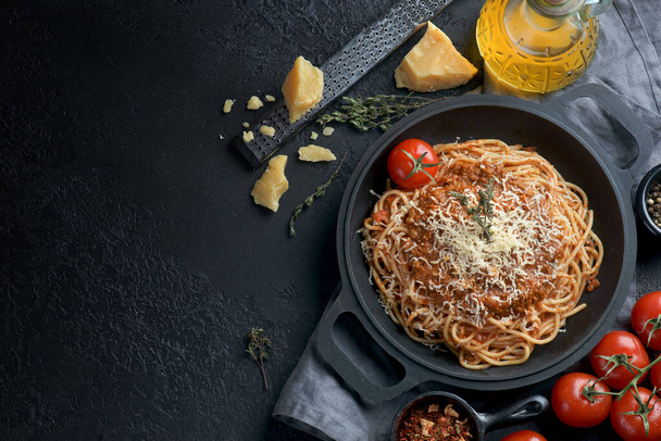 spaghetti Bolognese in a pan on a dark background - Fotoğraf, Görsel