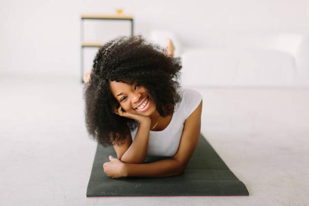 An African American young woman doing physical exercises in a mat - Φωτογραφία, εικόνα