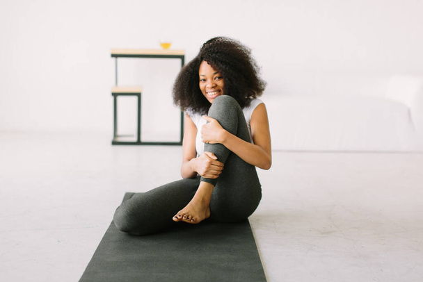 An African American young woman doing physical exercises in a mat - Fotografie, Obrázek