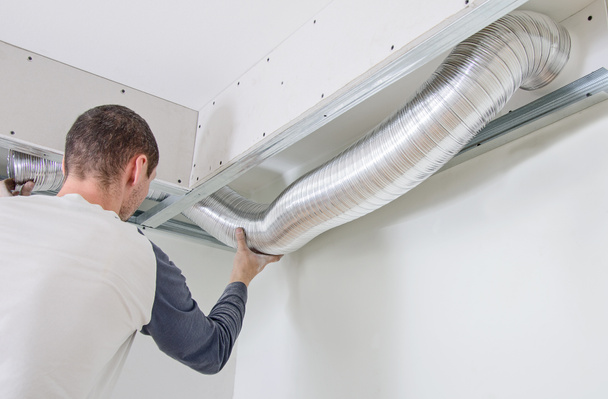 Hombre instalando sistema de ventilación en interiores
 - Foto, imagen