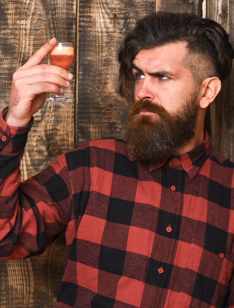 Suspicious drink concept. Barman with beard and serious face - Foto, imagen
