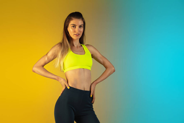 Fashion portrait of young fit and sportive woman on gradient background. Perfect body ready for summertime. - Foto, Imagem