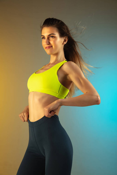 Fashion portrait of young fit and sportive woman on gradient background. Perfect body ready for summertime. - Photo, Image