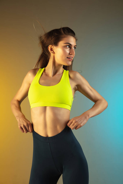 Fashion portrait of young fit and sportive woman on gradient background. Perfect body ready for summertime. - Foto, Imagem