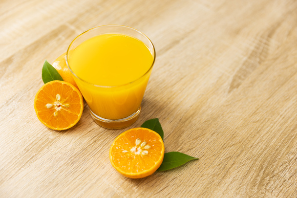 Pomerančový džus na dřevěném stole v kuchyni doma. Horní pohled - Fotografie, Obrázek