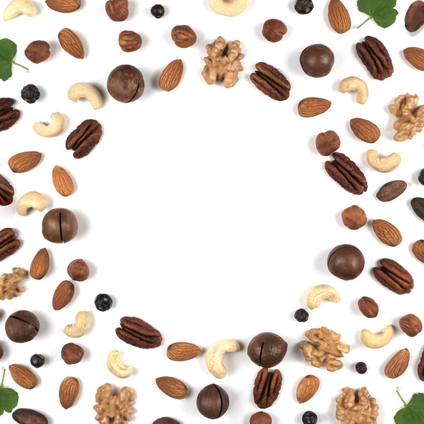 A pattern of nuts on a white background, decorated with green leaves. - Foto, immagini