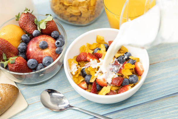 健康的な朝食。閉じる木製のテーブルの上にシリアルボウルに牛乳を注ぐ.健康食品 - 写真・画像
