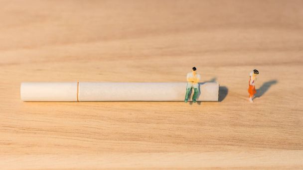 Miniature people couples lovers give up because of cigarettes with copy space - Photo, Image