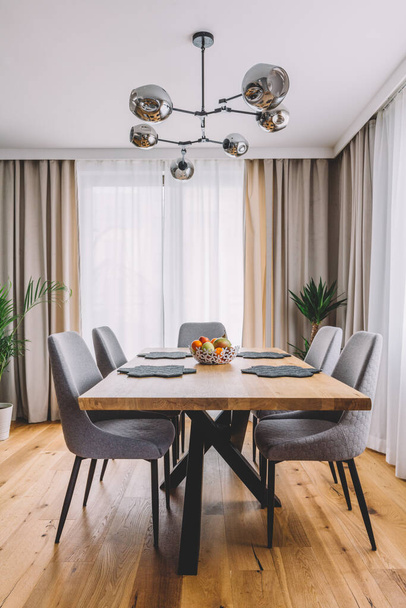 Sala de jantar com mesa de madeira e piso em apartamento moderno. Design de interiores
 - Foto, Imagem